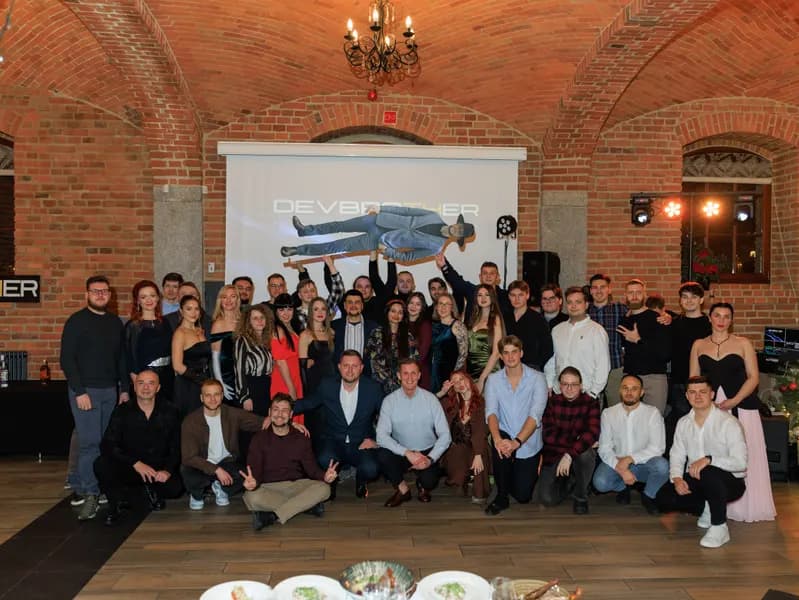 DevBrother team at a party in a brick-vaulted hall