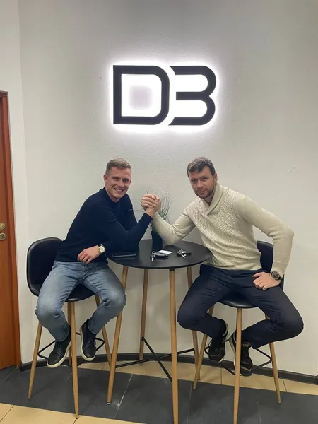 Two teammates arm wrestling under the DevBrother logo
