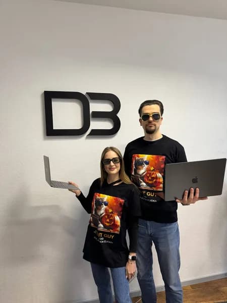 Teammates in matching Halloween tees holding laptops under the DevBrother logo